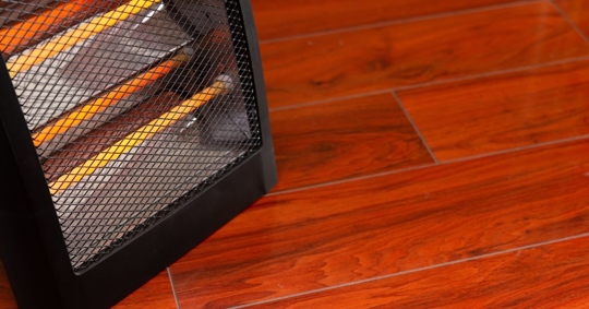 Close up of a space heater on a wooden floor