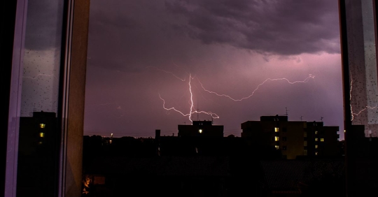 lightning in the sky over buildings
