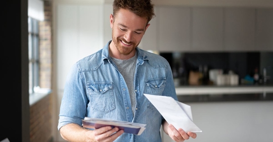 man smiling looking at AC bill