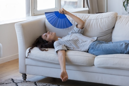 woman on couch with fan
