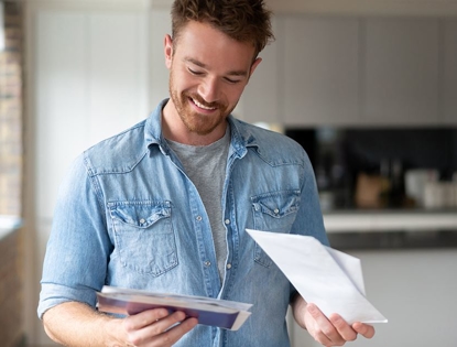 man smiling looking at AC bill